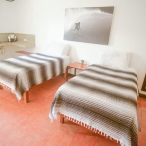 Photo of a guy surfing hung above two beds in a hotel room