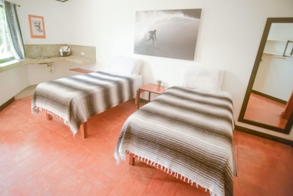 Photo of a guy surfing hung above two beds in a hotel room