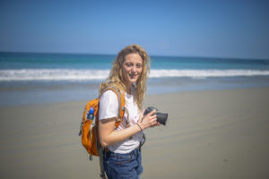 Girl with camera on the beach