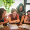 Spanish language teacher instructing her smiling students.