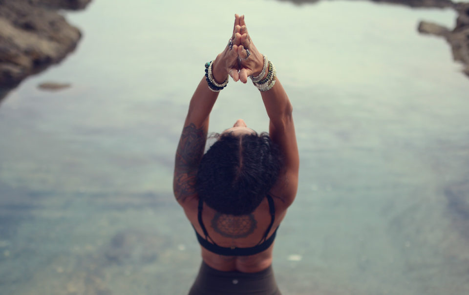 Woman doing a yoga backbend on the beach