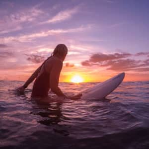 female surfer at sunset costa rica