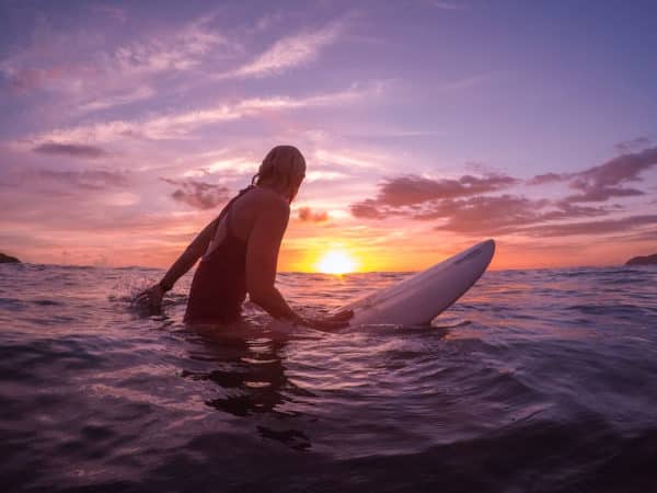 female surfer at sunset costa rica