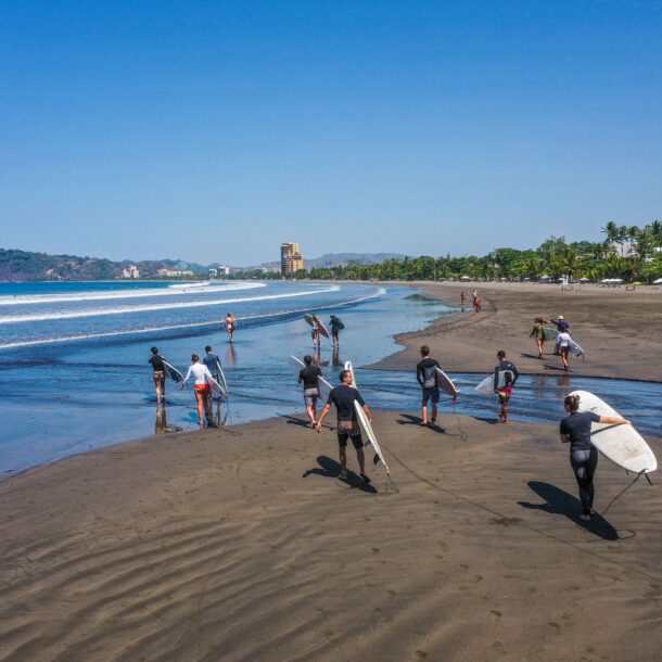 surfings walking on a beautiful beach in Costa Rica