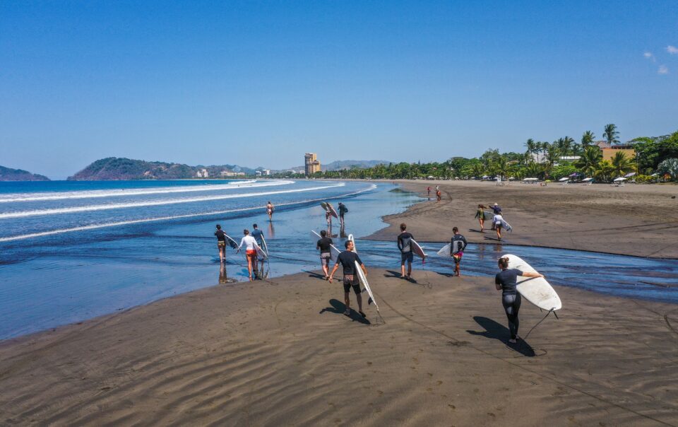 surfings walking on a beautiful beach in Costa Rica